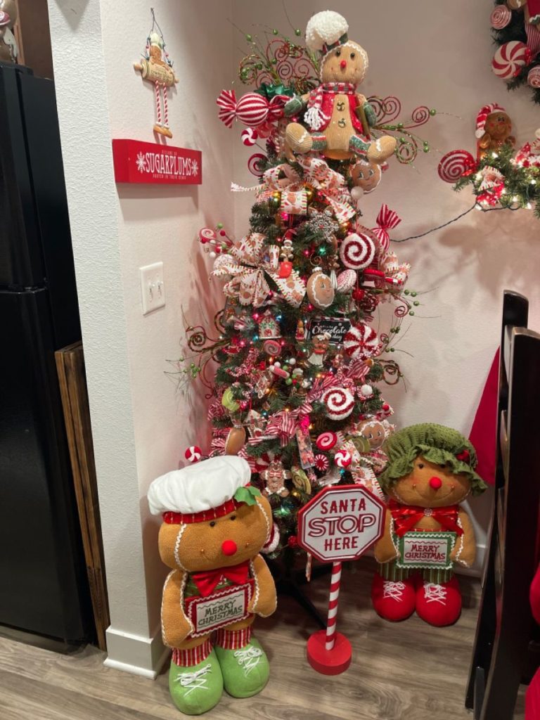 Christmas tree topped with a gingerbread star-shaped topper, decorated with intricate frosting designs and colorful sprinkles, adding a unique and charming touch to the holiday décor.