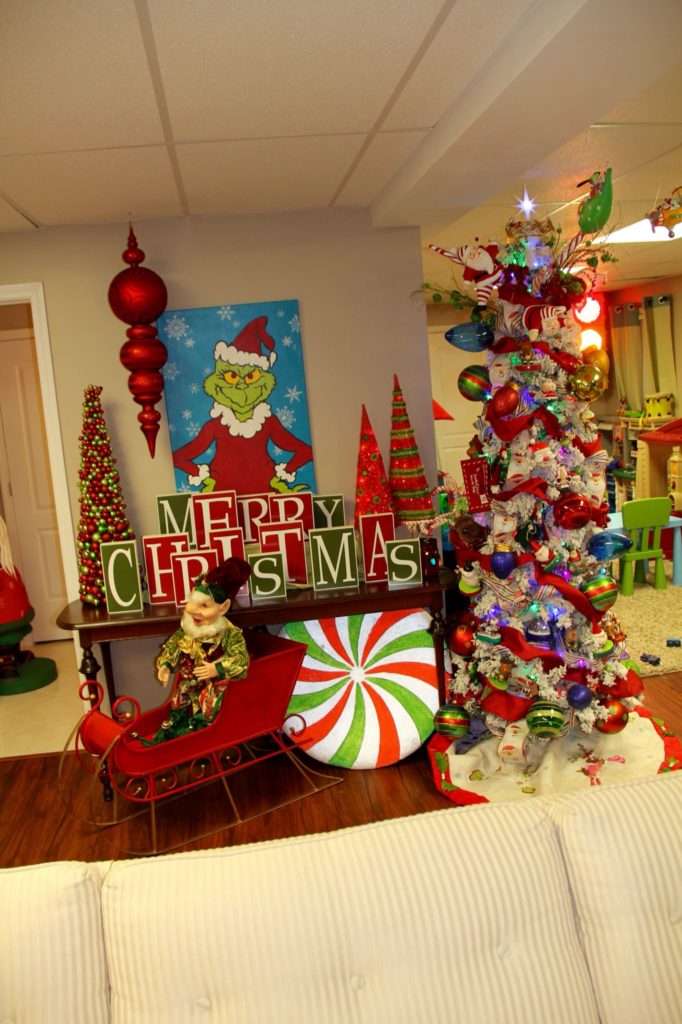 Grinch-themed Christmas garland with plush paws, No Caroling Zone signs, and green tinsel.