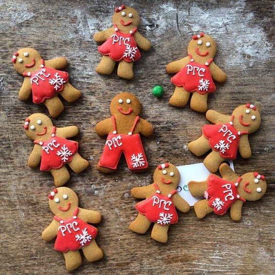 festive holiday table setting with personalized gingerbread place card holders, each decorated with frosting, sprinkles, and edible embellishments, holding small cards with guests' names.